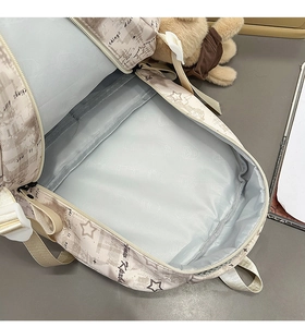 Macro view of large main compartment with gray lining in printed canvas backpack