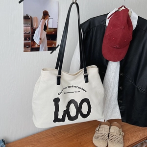 Retro canvas tote bag with black leather straps hanging in a lifestyle urban setting
