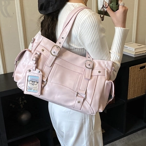 Dettaglio della borsa tote rosa con fibbie decorative, rivetti e tasche esterne pratiche