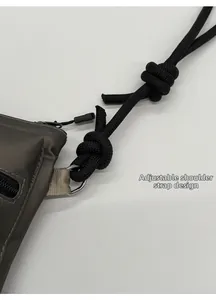 Detail view of the charcoal nylon bag with an adjustable black woven rope strap design