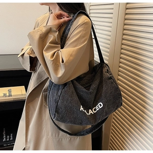 Minimalist grey denim tote bag with white RELACED text shown on a fashion model