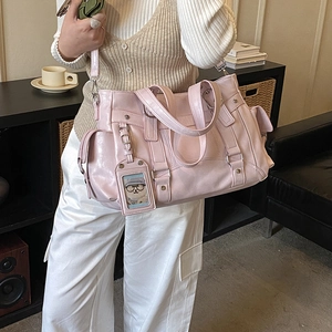 Dettaglio della borsa tote in pelle PU rosa con tasche multiple e ciondolo a orso