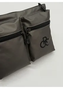 Close-up of waterproof nylon shoulder bag featuring dual zippered pockets and geometric logo