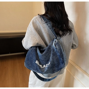 Detail view of the large capacity blue denim tote bag with white REPLAC logo text