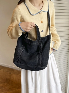 Classic black denim tote bag with white contrast stitching and versatile carry handles