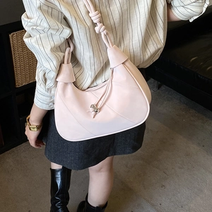 Detail of light pink hobo bag with knotted strap and metal bead drawstring on a model