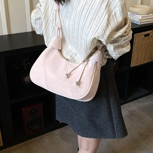 Detail of light pink dumpling shoulder bag with drawstring texture and crescent shape