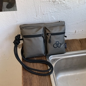 Detailed view of deep grey waterproof nylon multi-pocket crossbody bag with rope strap