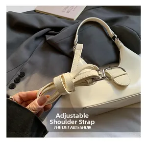 Close-up of adjustable shoulder strap with metal buckle on white dumpling bag