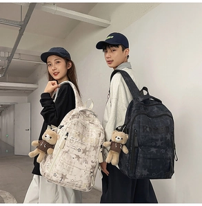 Detail of high-density nylon backpack with star pattern and cute teddy bear pendant