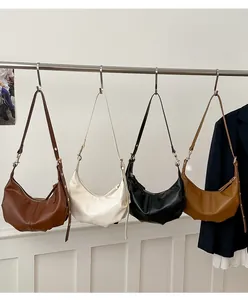 Detail view of four minimalist faux leather hobo bags in brown, beige, black, and tan colors