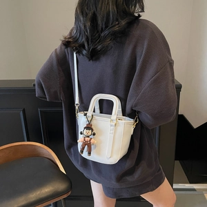 Sac seau minimaliste en cuir blanc avec poignée supérieure et joli charme de dessin animé