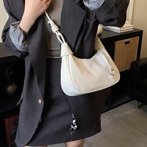 Detail of white moon hobo bag featuring drawstring accents and metallic bead details
