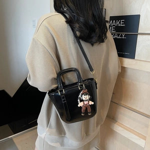 Sac seau noir brillant chic avec pendentif ourson et bandoulière amovible