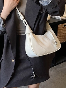Minimalist white hobo bag with knot strap and silver beads shown on shoulder