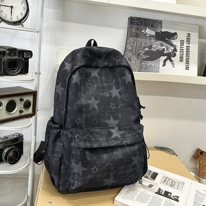 Dettaglio dello zaino scolastico nero con motivi a stelle in un ambiente stile vintage