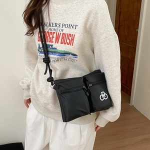 Detail view of durable black nylon crossbody bag featuring double zip pockets and rope strap