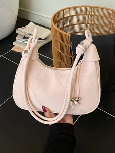 Minimalist light pink crescent shoulder bag with quilted texture and knot strap details