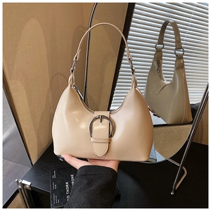 Detail of cream white faux leather crescent bag with a large silver horseshoe buckle