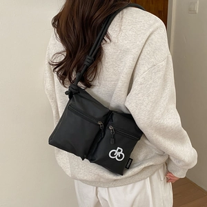 Detail of black nylon crossbody bag with double zip compartments and thick rope strap