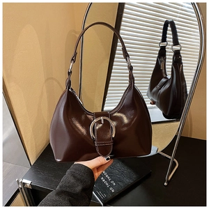 Detail of dark brown leather crescent hobo bag featuring a large silver ring buckle