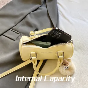 Detail view of yellow leather cylinder bag interior fitting a phone and makeup