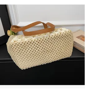 Close-up of beige woven mesh tote bag featuring brown leather shoulder straps and net texture