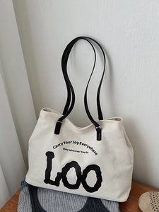 Minimalist cream canvas tote bag with black leather straps and stylish text print