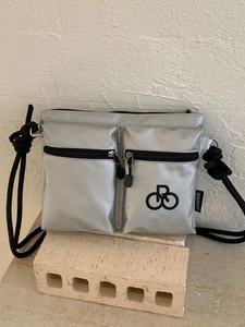 Waterproof silver nylon crossbody bag with dual zipper pockets and black rope strap