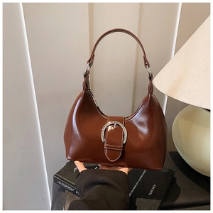 Detailed macro view of the glossy brown leather hobo bag with its silver metal buckle