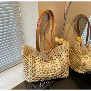 Detail showing handwoven hollow geometric texture and brown leather straps of the tote bag