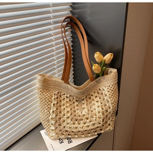 Detail of hollow crochet straw tote bag showing woven geometric texture and brown leather strap