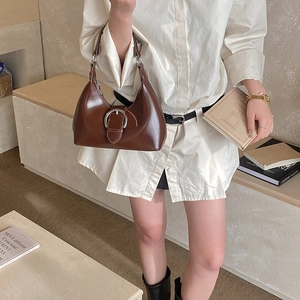 Detail of a dark brown vintage hobo bag with an oversized silver metal buckle decoration