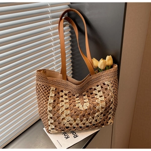Detailed macro view of the handcrafted woven straw tote bag with floral crochet pattern