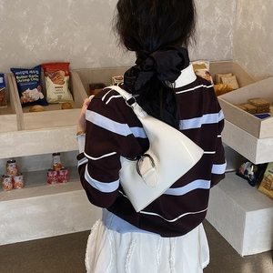 White faux leather hobo shoulder bag with silver horseshoe buckle on a model