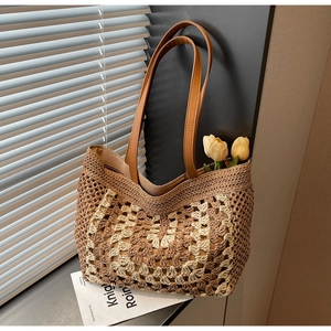Detailed close-up of woven checkered pattern and brown leather straps on large straw tote bag