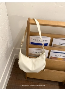 Detail of the elegant cream pleated hobo bag with adjustable strap and gold metal buckle