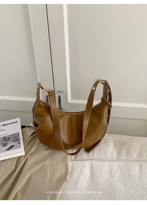 Detail showing retro brown pleated crescent bag with adjustable strap and metal zipper