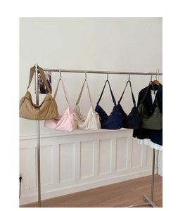Detailed view of lightweight nylon dumpling bags in six trendy colors hanging on a rack