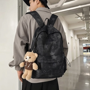 Zaino nero con stelle e ciondolo orsetto di peluche indossato da modello uomo