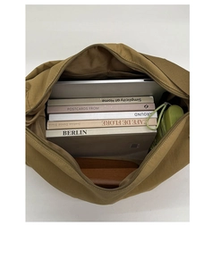 Top view of large brown nylon dumpling bag with laptop compartment and magazines