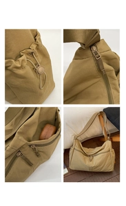 Detail of khaki nylon dumpling bag showing smooth zippers, wide strap, and side pockets