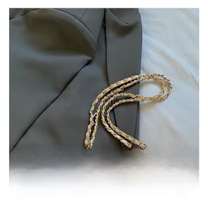 Detailansicht der rosa gesteppten Tasche mit goldener Kette und gewebtem Lederriemen