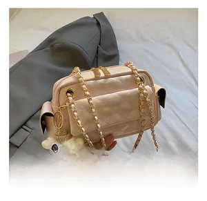 Detailansicht der rosa Steppledertasche mit Doppelreißverschluss und Plüsch-Anhänger