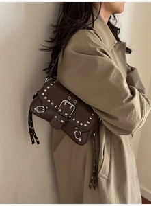 Detail of dark brown vintage faux leather shoulder bag with silver rivet studs and buckle