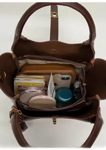 Top view of dark brown leather bucket bag interior showing spacious storage and golden lock