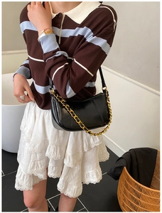 Detailaufnahme einer schwarzen Hobo-Bag mit klobiger Goldkette und Halbmond-Form