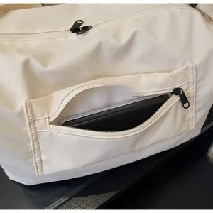Makroaufnahme der vorderen Reißverschlusstasche der beigen Canvas-Reisetasche mit Nähten