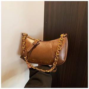 Detailansicht der braunen Retro-Halbmondtasche mit Goldkette und Lederriemen-Detail