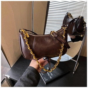 Nahaufnahme einer vintage dunkelbraunen Achseltasche mit Struktur und goldener Kette